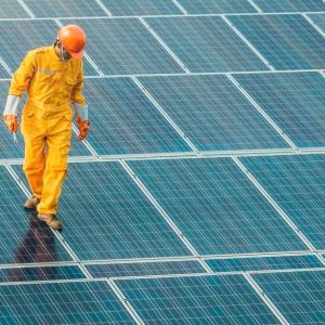 Worker walking on solar panels