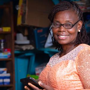 Person smiling while using smartphone at a business