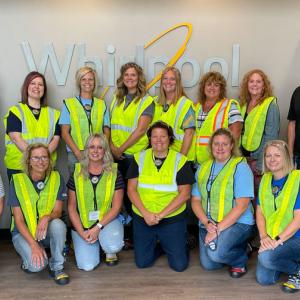 Group of teachers in yellow vests in front of Whirlpool Sign