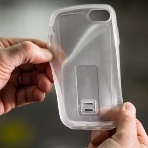 Two hands holding a clear, flexible, plastic device cover.