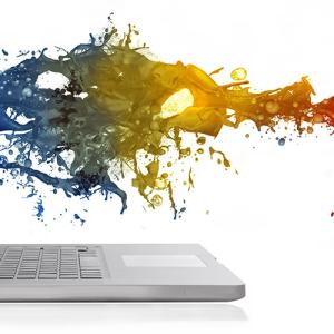 A spray of multi-colored liquid splashing on a laptop screen