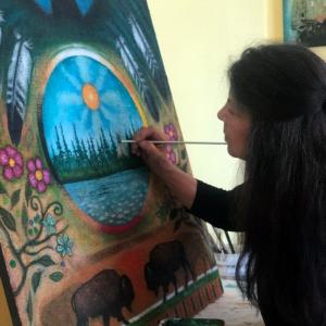 Artist Nancy Desjarlais working on a colorful painting