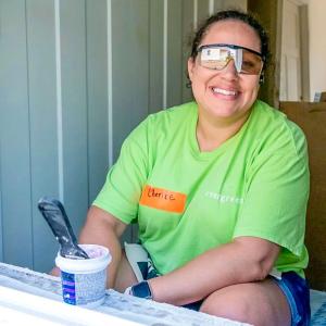A smiling volunteer sitting in an open window.