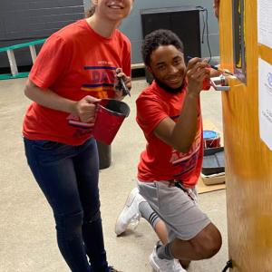 two people with paint and brushes