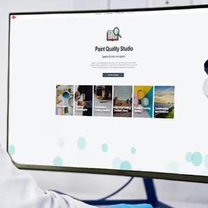 A person looking at a computer screen, a microscope to the side.