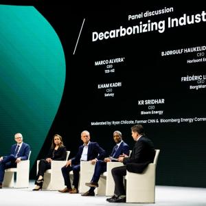 Panel on stage with large screen behind them