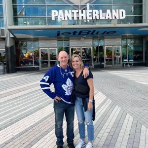 Andy O'Brien and another person with arms around each other in front of an arena "Pantherland".