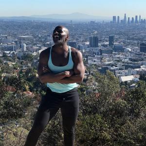 Paris Mullen stands outside with background of a large city
