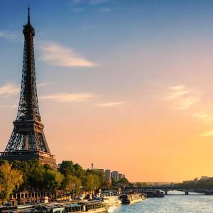 Eiffel Tower with a setting sun to the side.