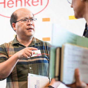 Henkel employees talking, carrying paperwork