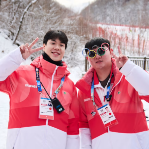 2 people make peace signs with their hands