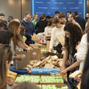 a big group of people assemble bags of period products