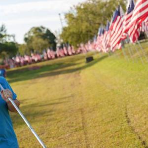 Person holding an American Flag with flags in the background