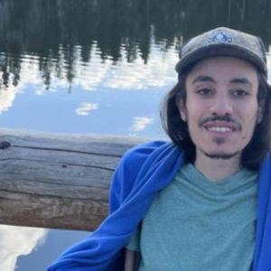 Peter Mansour, a forested body of water behind them.