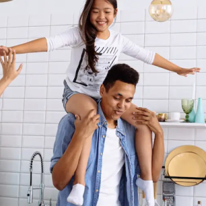 Child playing on parents shoulders