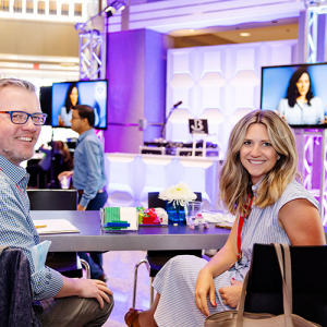 2 people smiling at conference booth