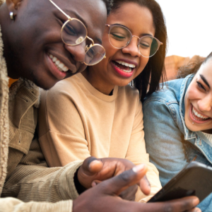 Three people look at a smartphone