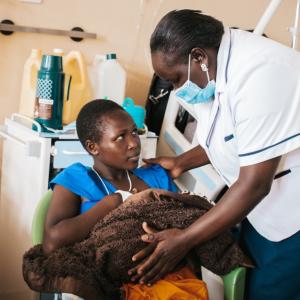 A nurse helps a young mother position her baby for breastfeeding at Kapenguria Hospital, Kenya.