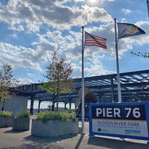sign for Pier 76 and three flags