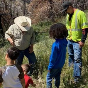 children and adults outside in a grassy area