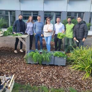 A group posed outside, behind planters