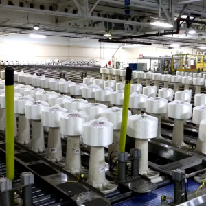 Dozens of Naia Renew fiber bobbins ready for packaging in an Eastman facility.