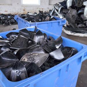 Containers of black plastic pieces