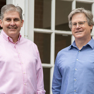 Two people standing in front of windows
