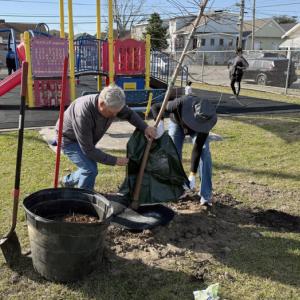 People helping clean up next to a playground