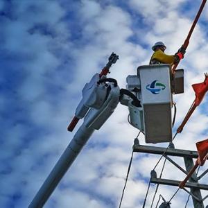 A line worker in a bucket truck working on a power line