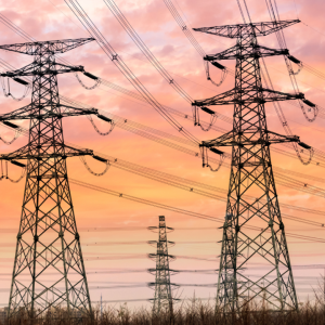 Tall power lines, a sunset sky behind.