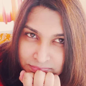 Tanvi in a red shirt, with her chin in her hand