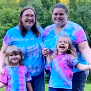 Amber with her wife and two children, all in tie-dye t-shirts