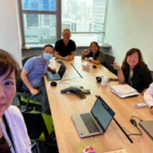 A group of people at a long office table looking at the camera.