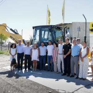 A group of people posed in front of a large construction vehicle
