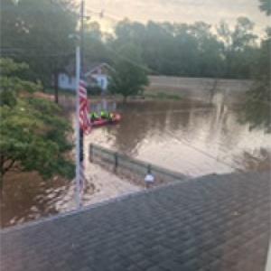 Homes flooded by recent storms. Flag pole is shown with flood waters rising up.