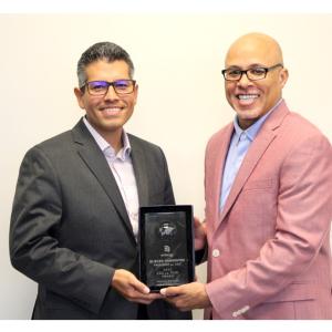 Eliecer “Eli” Viamontes receiving award from another person