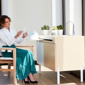 A person sitting in a specialized chair looking at a breast pump