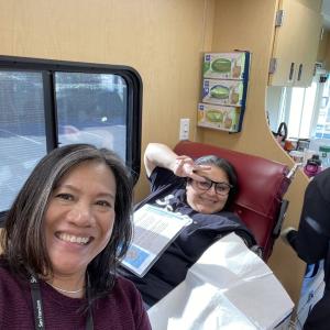 person donating blood with helpers