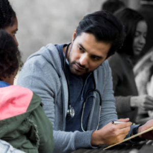 a doctor sits writing on a clipboard, an adult and child on the left