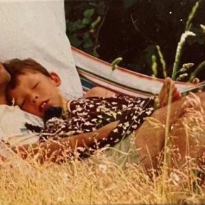 father and child sleeping in a hammock