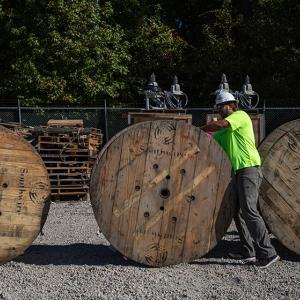 Worker rolling a wooden spool