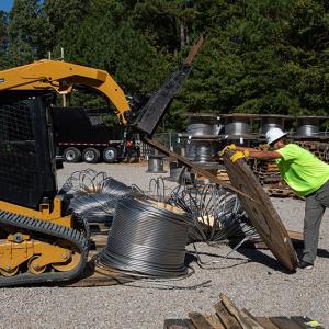 Workers dismantling a wooden spool
