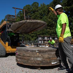 Worker dismantling a wooden spool