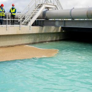 Two employees looking down on water