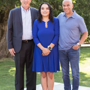 3 peple stand together smiling