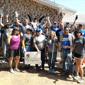 Volunteers in front of a "rebuilding together" sign