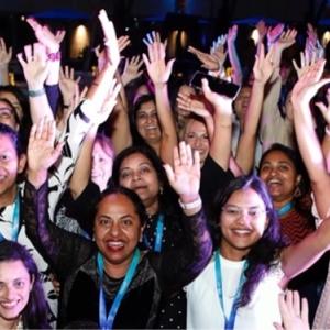 A group of people posed, arms raised.