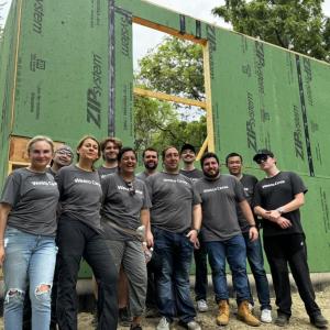 A group smiling in front of building construction