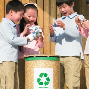 Children around a recylcing container